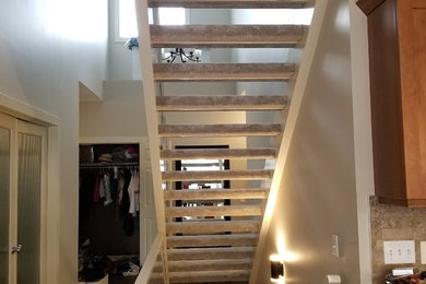 Example of a mid-sized carpeted straight open and mixed material railing staircase design in Calgary