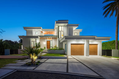 Example of a large trendy white two-story stucco exterior home design in Tampa