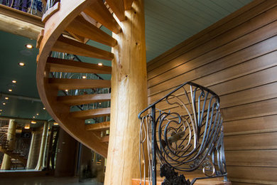他の地域にあるラグジュアリーな巨大なトラディショナルスタイルのおしゃれならせん階段 (木の蹴込み板、金属の手すり) の写真