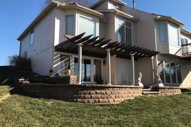 Example of a tuscan backyard patio design in Kansas City with a pergola