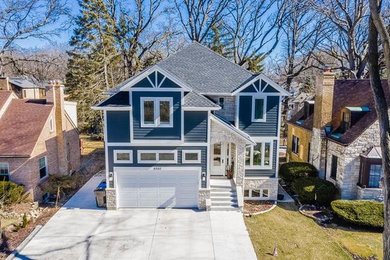 Example of a mid-sized transitional blue two-story vinyl house exterior design in Chicago with a hip roof and a shingle roof