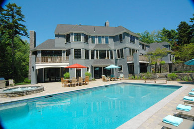This is an example of a large backyard rectangular pool in Portland Maine with a hot tub and brick pavers.