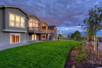 Large transitional brown two-story stucco gable roof photo in Denver