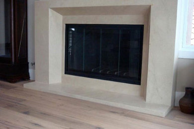 Living room - modern light wood floor and beige floor living room idea in Seattle with white walls, a standard fireplace and a stone fireplace