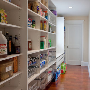 Idée de décoration pour une grande arrière-cuisine linéaire tradition avec un placard sans porte, des portes de placard blanches, un sol en bois brun et un sol marron.