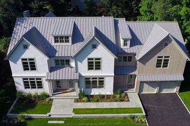 Large contemporary gray three-story wood exterior home idea in New York