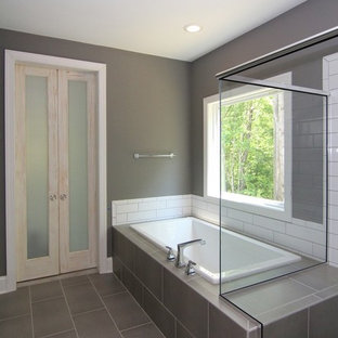 Foto di una grande stanza da bagno padronale country con ante con riquadro incassato, ante bianche, vasca ad angolo, doccia ad angolo, WC monopezzo, pareti grigie, pavimento con piastrelle in ceramica, lavabo sottopiano, top in granito, pavimento grigio, porta doccia a battente e top grigio