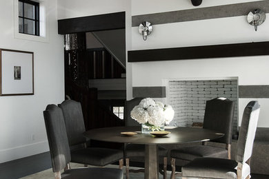 Example of a trendy dark wood floor dining room design in Salt Lake City with multicolored walls and a standard fireplace