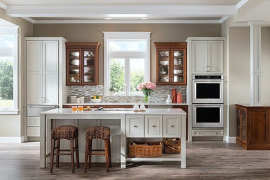 Eat-in kitchen - mid-sized transitional galley ceramic tile eat-in kitchen idea in Other with an undermount sink, recessed-panel cabinets, white cabinets, granite countertops, gray backsplash, mosaic tile backsplash, stainless steel appliances and an island