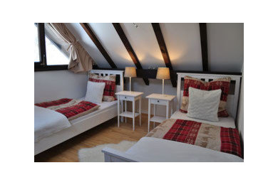 Mittelgroßes Rustikales Gästezimmer ohne Kamin mit weißer Wandfarbe, braunem Holzboden und beigem Boden in München