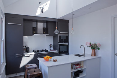 Design ideas for a contemporary eat-in kitchen in London with an undermount sink, flat-panel cabinets, grey cabinets, quartzite benchtops, white splashback, stainless steel appliances, dark hardwood floors and with island.