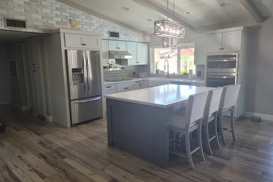 Inspiration for a large transitional vinyl floor open concept kitchen remodel in Phoenix with shaker cabinets, gray backsplash, ceramic backsplash, an island and white countertops