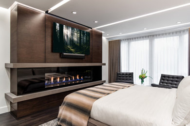 This is an example of a mid-sized contemporary master bedroom in Vancouver with white walls, dark hardwood floors, a ribbon fireplace, a concrete fireplace surround and brown floor.