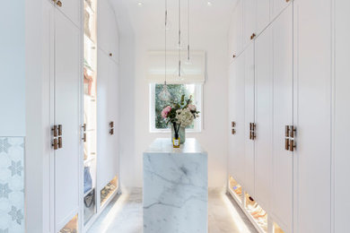 Inspiration for a medium sized contemporary dressing room for women in London with shaker cabinets, white cabinets, marble flooring, white floors and feature lighting.