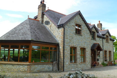 Inspiration for a large traditional two-storey house exterior in Other with stone veneer, a gable roof and a tile roof.
