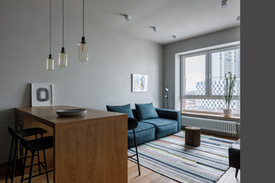На фото: открытая, объединенная гостиная комната среднего размера в современном стиле с серыми стенами, светлым паркетным полом и коричневым полом без камина