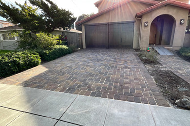 Photo of a mid-sized rustic full sun concrete paver driveway in San Francisco.