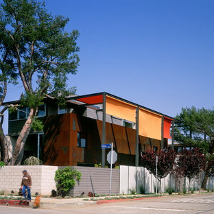 ロサンゼルスのインダストリアルスタイルのおしゃれな二階建ての家 (メタルサイディング、オレンジの外壁) の写真