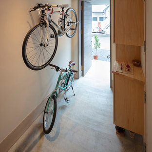 東京都下の片開きドアモダンスタイルのおしゃれな玄関 (白い壁、コンクリートの床、茶色いドア、グレーの床) の写真