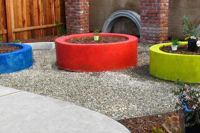 This is an example of a mid-sized eclectic drought-tolerant and partial sun backyard gravel landscaping in Los Angeles.