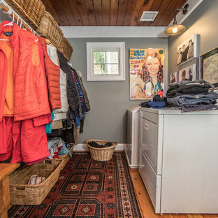 Imagen de lavadero de galera y multiusos, rústico, de tamaño medio, con paredes grises, suelo de madera en tonos medios, lavadora y secadora juntas y suelo marrón