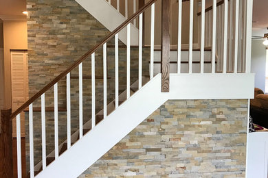 Modelo de escalera en U tradicional renovada de tamaño medio con escalones de madera, contrahuellas de madera pintada y barandilla de madera
