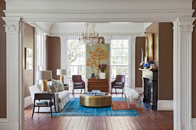 Large elegant formal and open concept medium tone wood floor living room photo in Charleston with brown walls, a standard fireplace and no tv