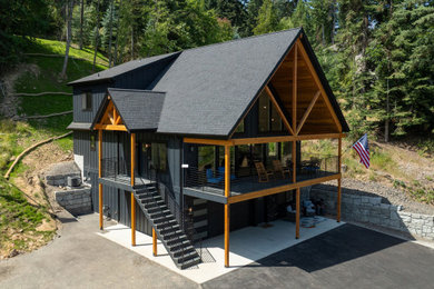 Mid-sized modern black three-story house exterior idea in Other with a black roof
