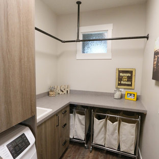 Inspiration for an urban l-shaped utility room in Little Rock with flat-panel cabinets, laminate countertops, a side by side washer and dryer and medium wood cabinets.