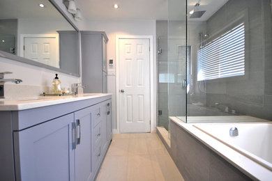 Inspiration for a mid-sized contemporary master bathroom in Toronto with shaker cabinets, grey cabinets, a drop-in tub, a corner shower, white walls, porcelain floors, an undermount sink, beige floor and a hinged shower door.