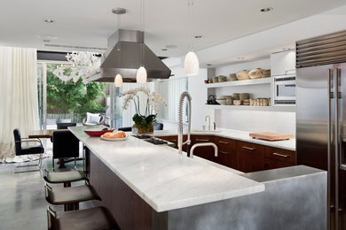 This is an example of a contemporary u-shaped eat-in kitchen in New York with white splashback and with island.
