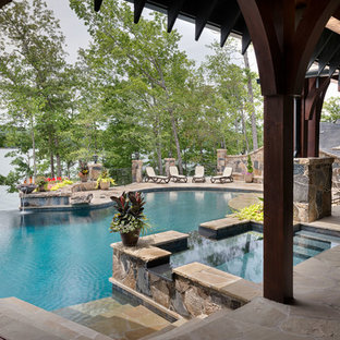 Foto på en rustik pool på baksidan av huset, med spabad och naturstensplattor