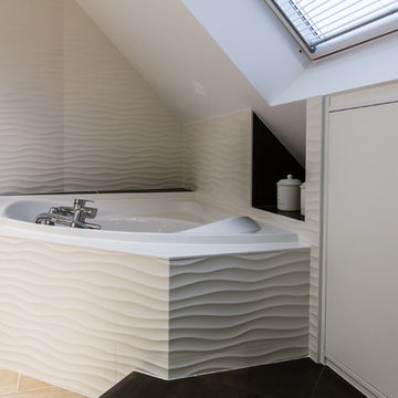 Baignoire d'angle sous partie mansardée avec faïence effet vagues.
