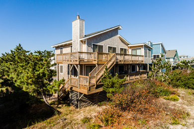 Inspiration for a large coastal brown three-story wood townhouse exterior remodel in Other with a clipped gable roof and a shingle roof