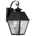 Livex Lighting - Mansfield Outdoor Wall Lantern, Black - Illuminate a driveway or terrace area with the Mansfield Wall Lantern. Modeled on traditional, Victorian-style lamps, it features a bronze shade with seeded glass panels suspended from a curved mount. The lantern is weatherproof and makes an elegant addition to an exterior wall or porch.