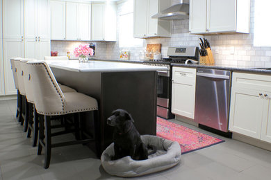 Inspiration for a large contemporary u-shaped porcelain tile kitchen remodel in Houston with an undermount sink, white cabinets, granite countertops, white backsplash, stone tile backsplash, stainless steel appliances and an island