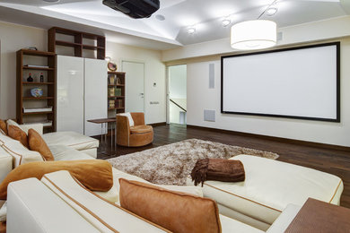 This is an example of a mid-sized modern enclosed home theatre in Boston with white walls, medium hardwood floors and a projector screen.
