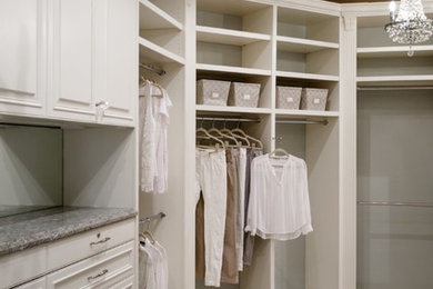 Example of a large classic gender-neutral carpeted dressing room design in Jacksonville with recessed-panel cabinets and white cabinets