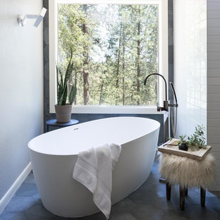 Immagine di una grande stanza da bagno padronale moderna con ante lisce, ante in legno bruno, vasca freestanding, WC monopezzo, piastrelle grigie, piastrelle in ardesia, pareti bianche, pavimento in ardesia, lavabo sottopiano, top in quarzo composito, pavimento grigio e porta doccia a battente