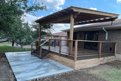 Deck - large backyard ground level mixed material railing deck idea in Austin with a roof extension