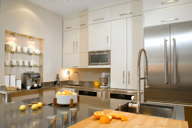 Eat-in kitchen - large modern l-shaped light wood floor eat-in kitchen idea in Montreal with stainless steel appliances, an undermount sink, flat-panel cabinets, white cabinets, quartz countertops, metallic backsplash, metal backsplash and an island