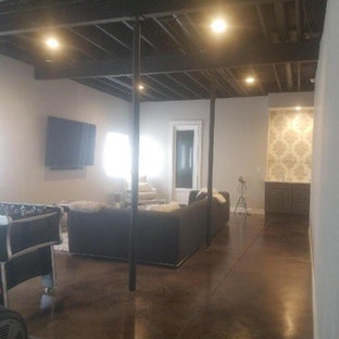 Large fully buried basement in Denver with concrete flooring and black floors.