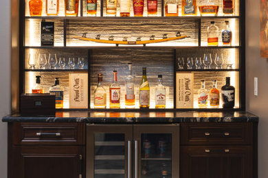 Home bar - southwestern home bar idea in Kansas City with granite countertops