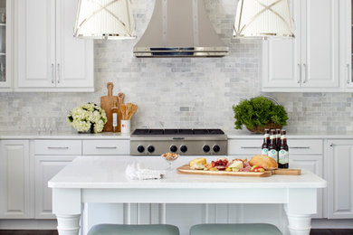Inspiration for a large transitional dark wood floor kitchen remodel in Atlanta with raised-panel cabinets, white cabinets, quartzite countertops, gray backsplash, stone tile backsplash, stainless steel appliances and an island