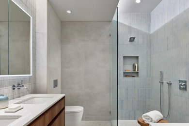 Bathroom - contemporary master porcelain tile and gray tile gray floor and double-sink bathroom idea in Philadelphia with flat-panel cabinets, medium tone wood cabinets, an undermount sink, a niche, a floating vanity, a one-piece toilet and white countertops