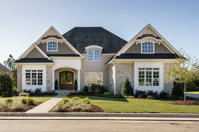 Example of a classic beige two-story mixed siding exterior home design in Raleigh with a hip roof