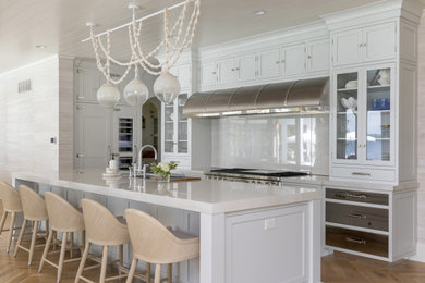 Example of a transitional medium tone wood floor and shiplap ceiling kitchen design in Milwaukee with an undermount sink, recessed-panel cabinets, quartzite countertops, stone slab backsplash, stainless steel appliances and an island