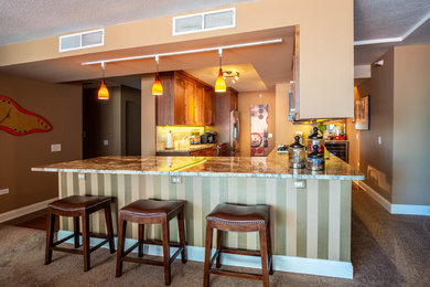 Example of a mid-sized classic u-shaped dark wood floor and brown floor enclosed kitchen design in Chicago with recessed-panel cabinets, medium tone wood cabinets, granite countertops, beige backsplash, ceramic backsplash, stainless steel appliances, an island, multicolored countertops and an undermount sink