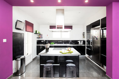Design ideas for a large contemporary l-shaped eat-in kitchen in Toulouse with an undermount sink, beaded inset cabinets, black cabinets, stainless steel benchtops, black splashback, ceramic splashback, stainless steel appliances, ceramic floors, with island, grey floor and grey benchtop.
