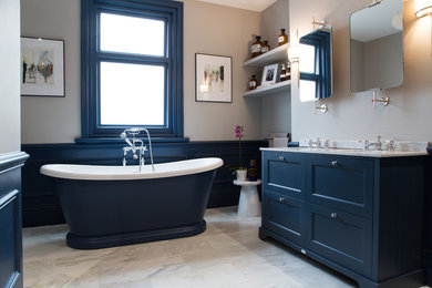 Photo of a mid-sized traditional master bathroom in Essex with furniture-like cabinets, blue cabinets, a freestanding tub, an alcove shower, a one-piece toilet, marble floors, a drop-in sink, marble benchtops, grey floor, an open shower and grey benchtops.